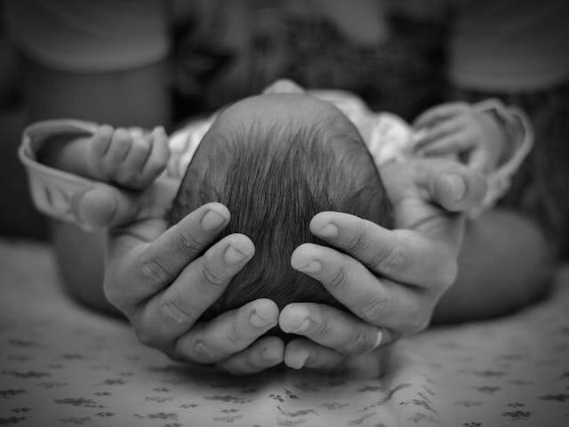 father holding a newborn baby in his hands