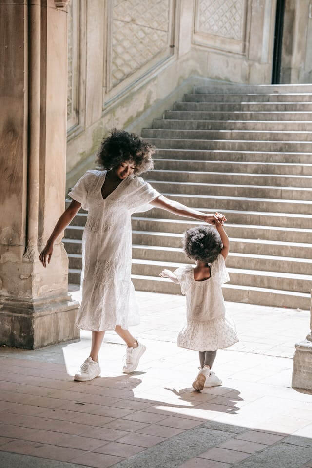 mom dancing with toddler near stairs