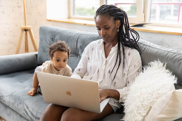 mom working on laptop with infant
