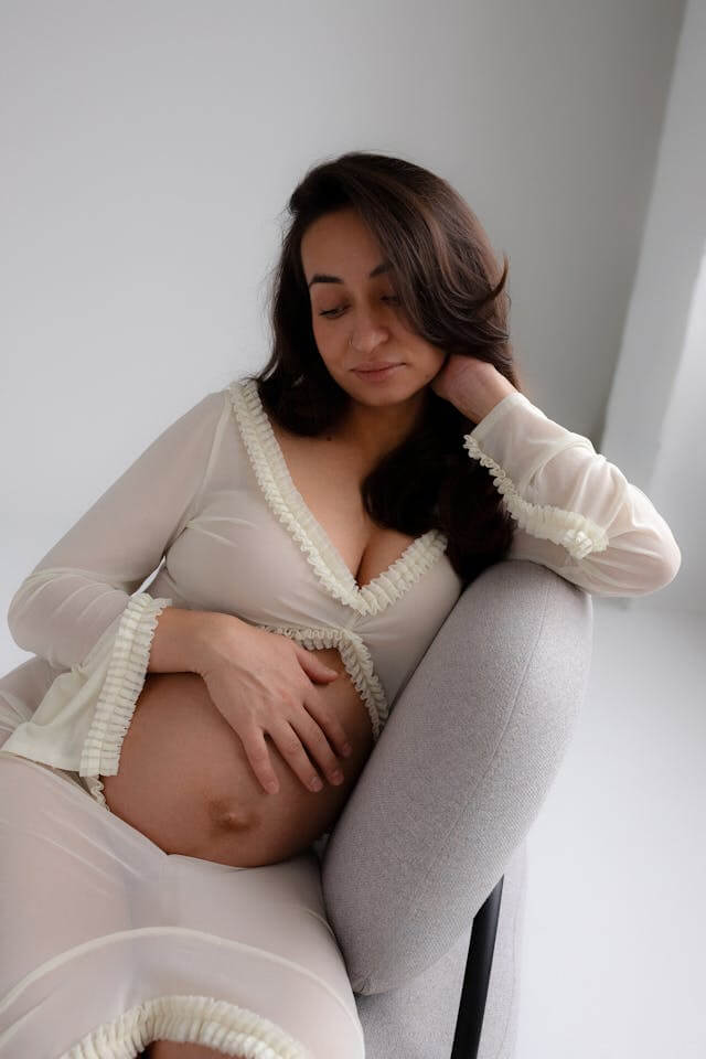 pregnant woman thinking with her hand on her belly