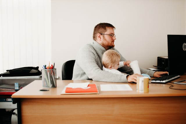 father working from home with toddler