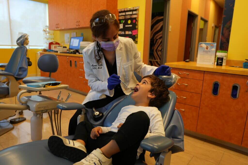 Dr. Afsoon Fazeli, DDS, MSD, performing a dental exam on a young child at Discovery Children's Dentistry & Orthodontics in Carlsbad, CA