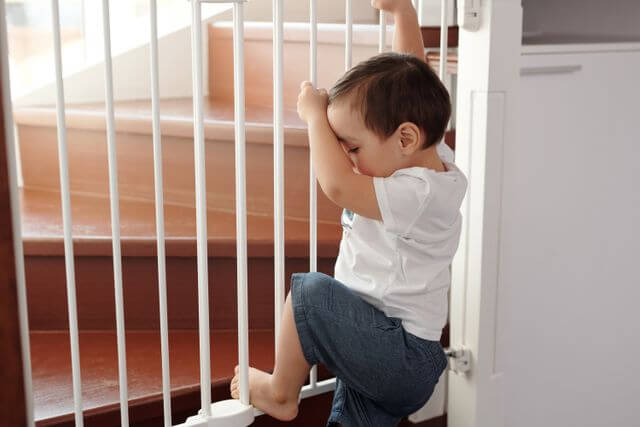 toddle climbing a toddler gate